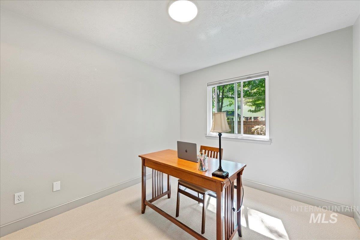 Home office featuring light carpet and baseboards