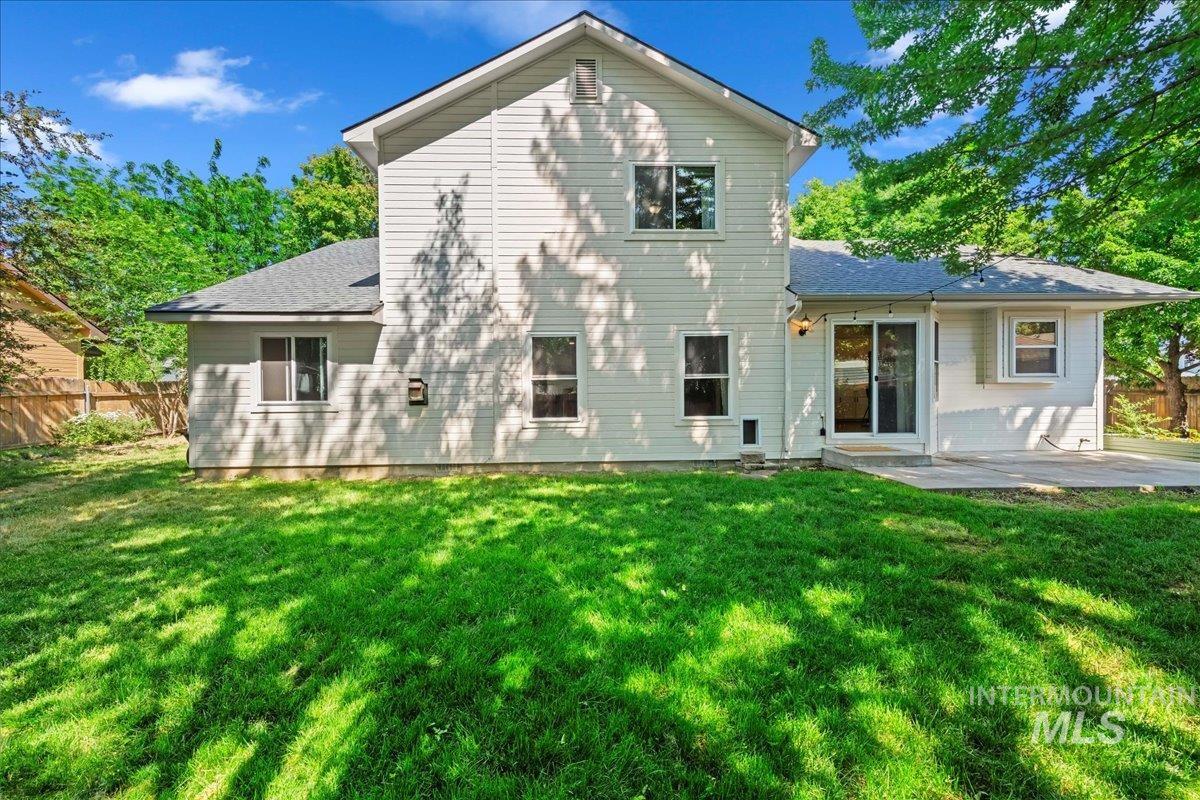 Rear view of house with a patio and roof with shingles