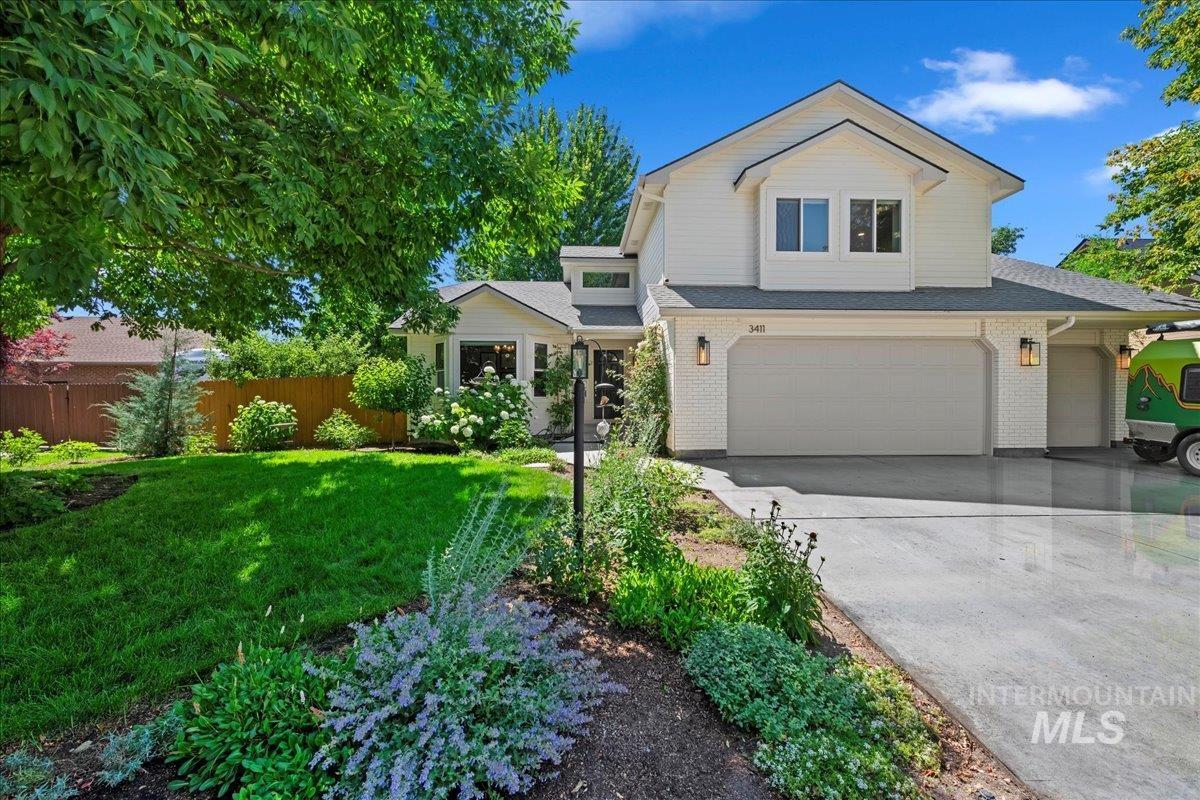 View of front of house with an attached garage, brick siding, concrete driveway, and roof with shingles
