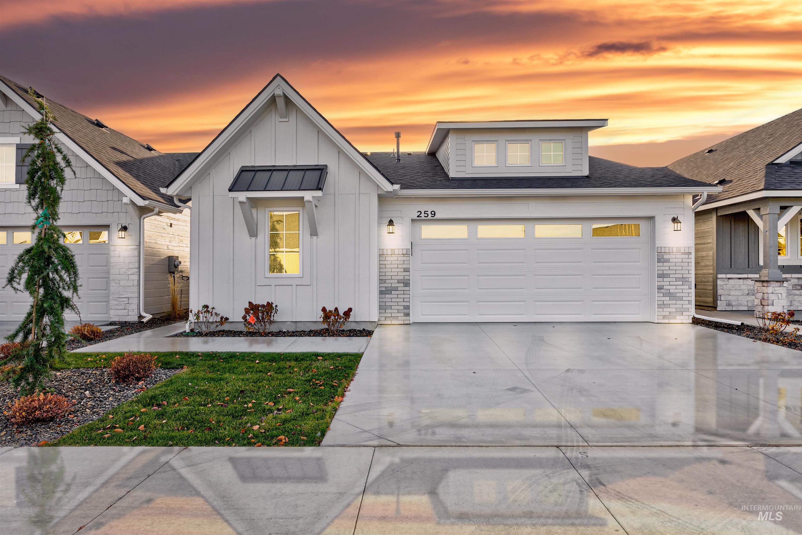 View of front of property with board and batten siding, concrete driveway, stone siding, a garage, and a shingled roof