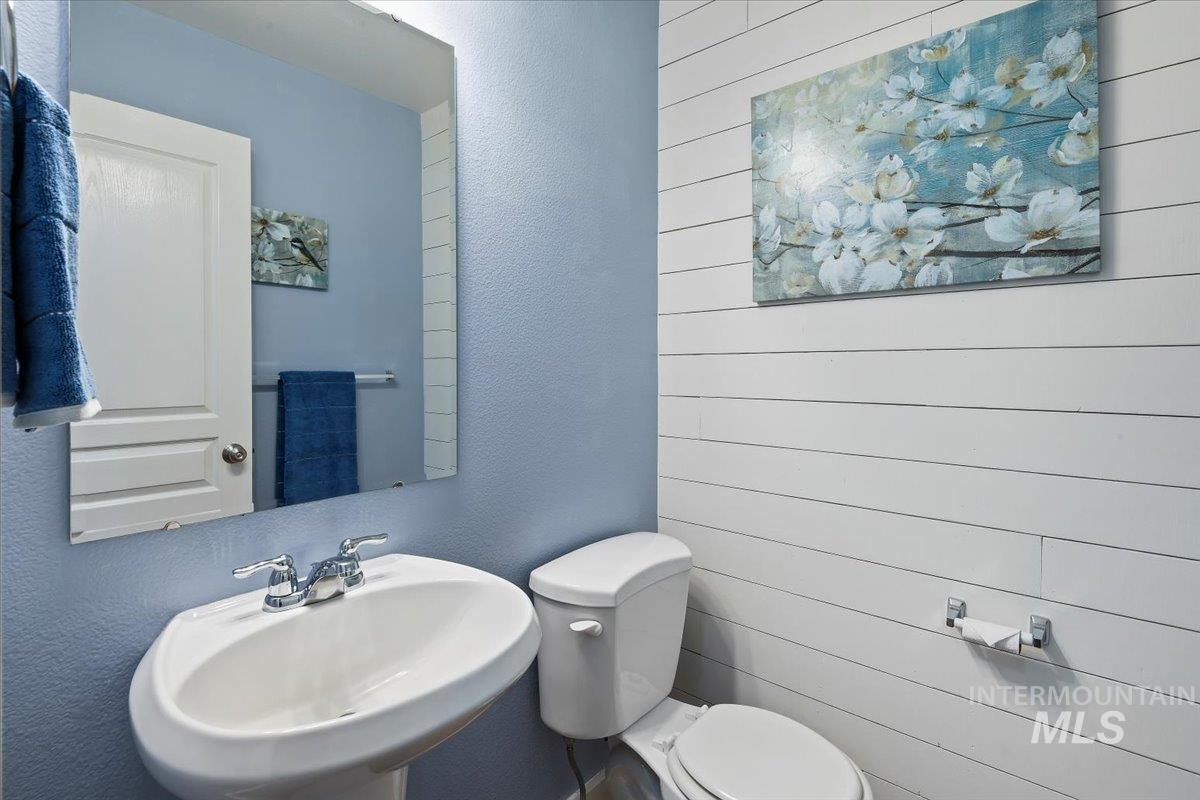 Half bath with a textured wall and a sink