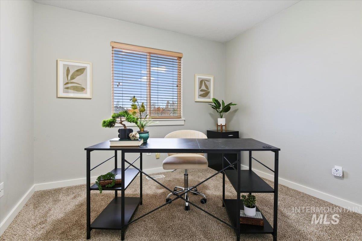 Carpeted office space with baseboards