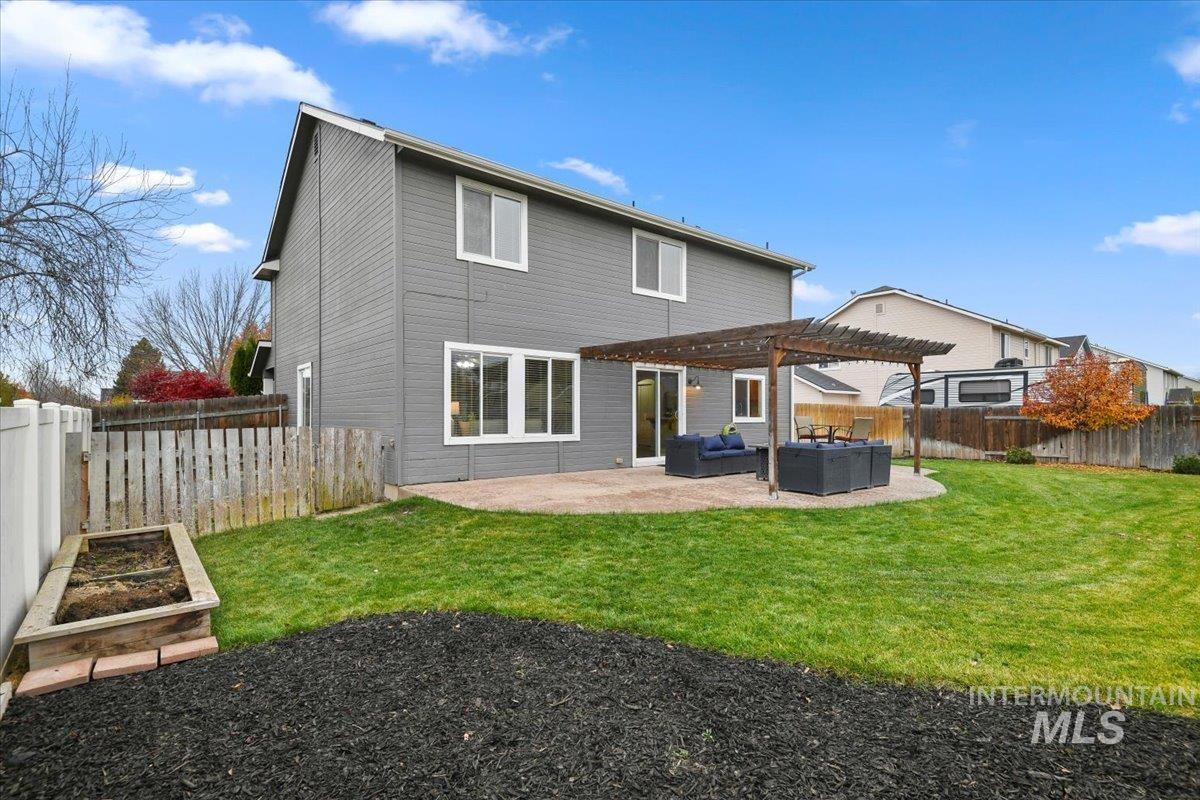 Rear view of property featuring a patio area, a fenced backyard, a pergola, an outdoor living space, and a vegetable garden