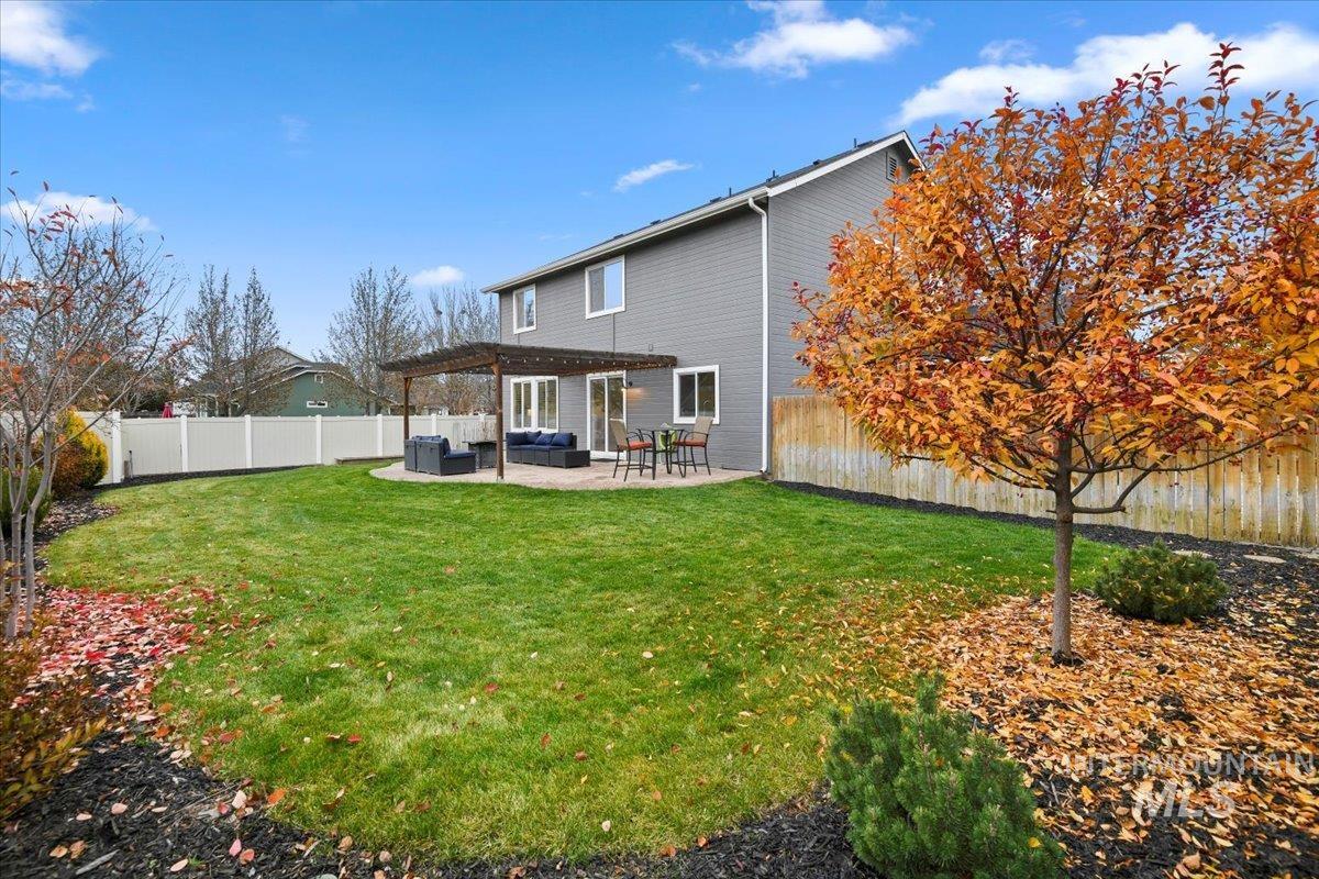 Rear view of property featuring a fenced backyard, a patio area, and a pergola