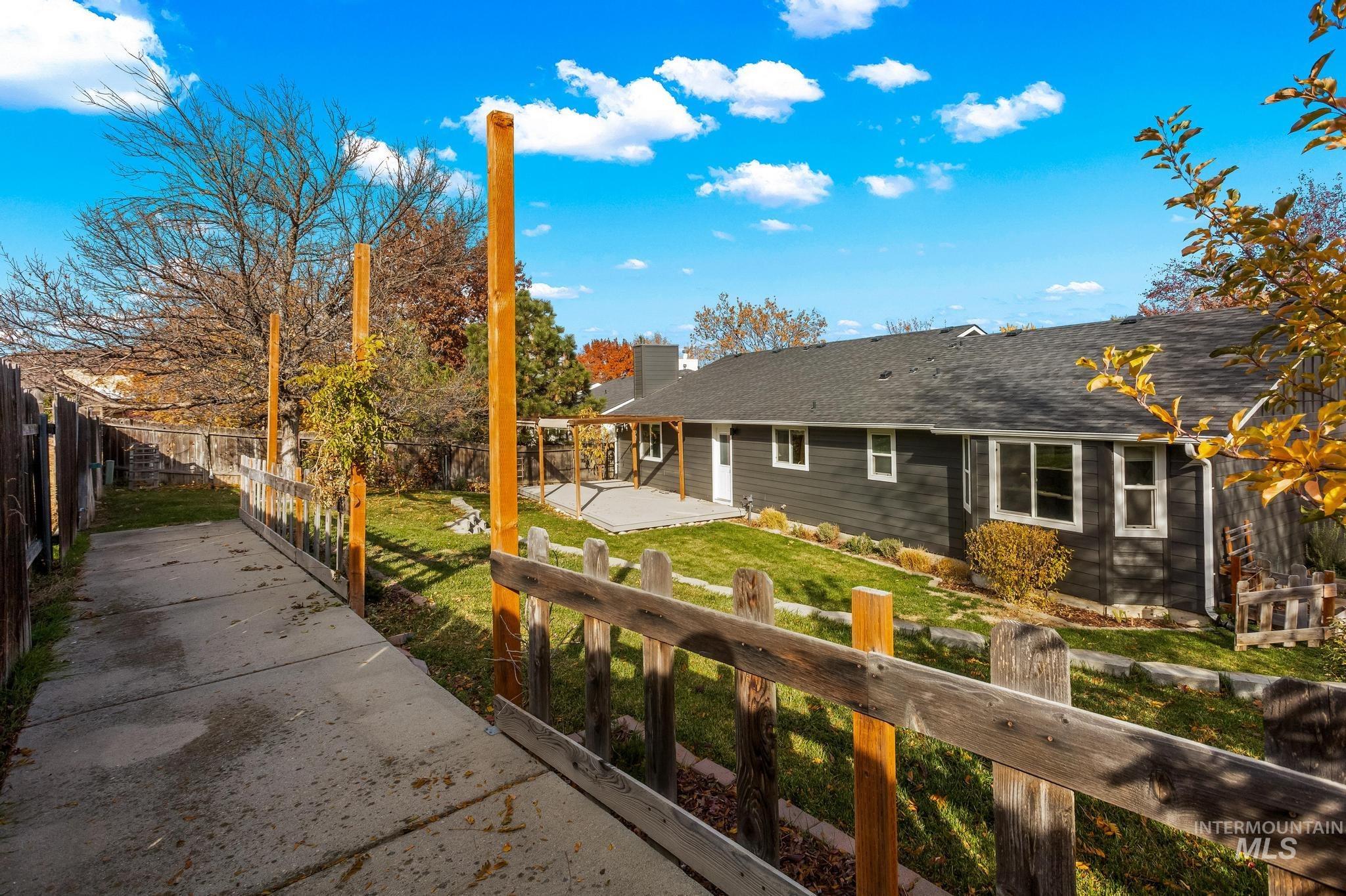Rear view of property featuring a fenced backyard, a patio area, a chimney, and a shingled roof
