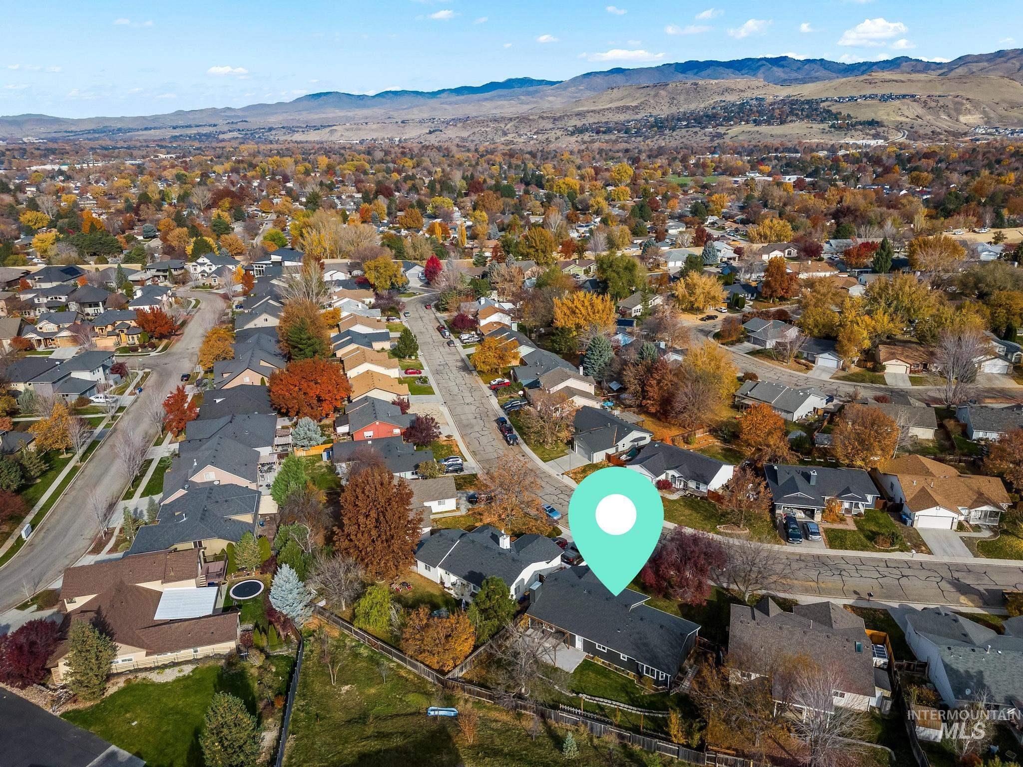 Aerial overview of property's location with a mountain backdrop and nearby suburban area
