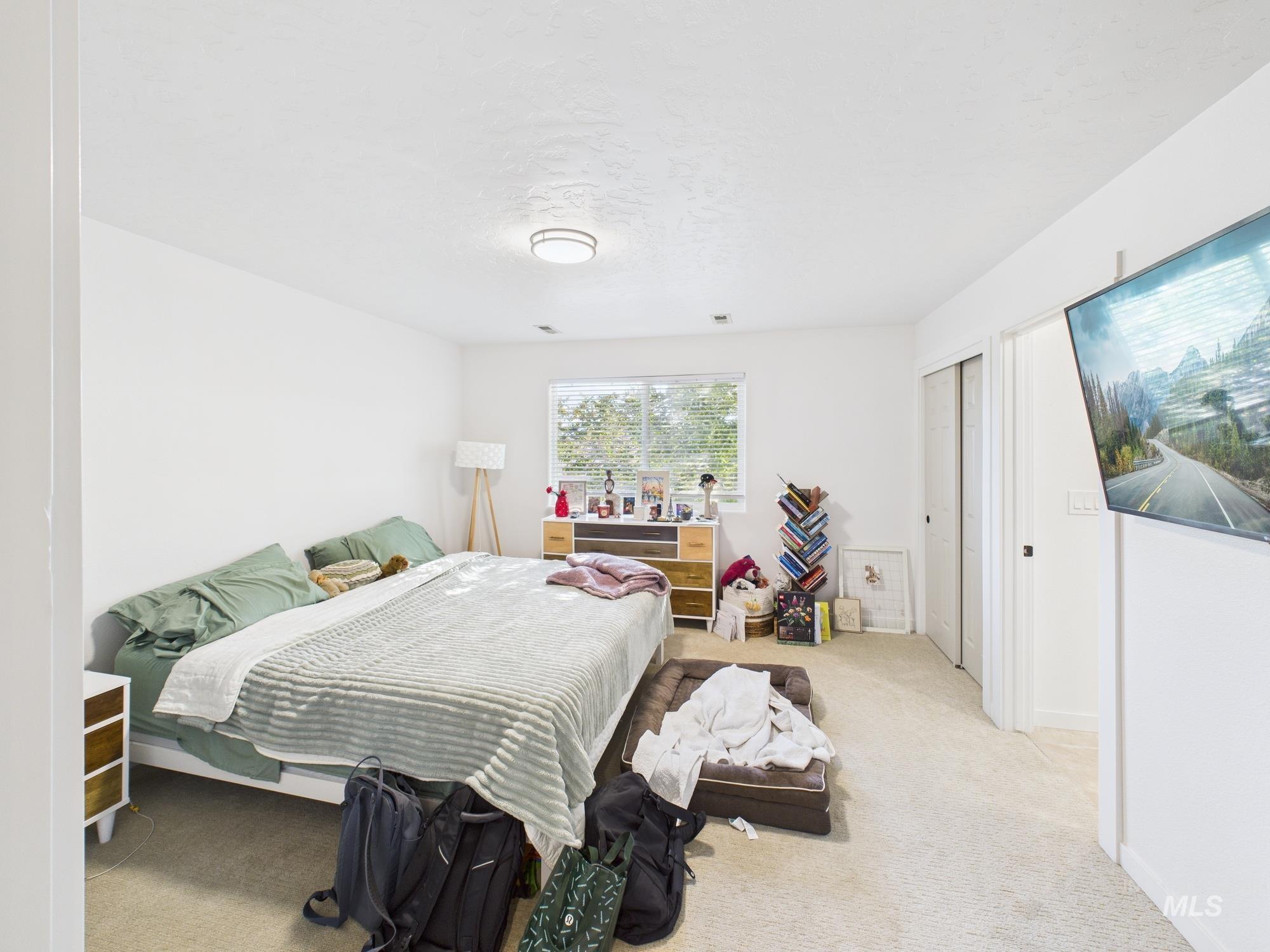 Carpeted bedroom featuring a closet and baseboards