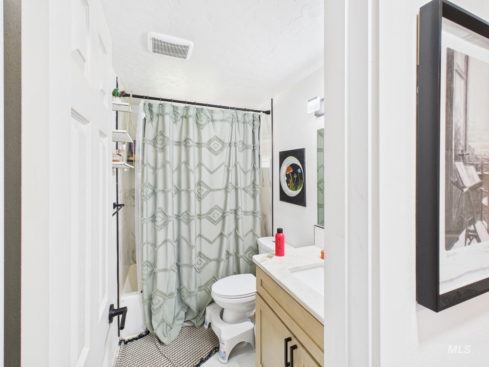 Full bathroom featuring shower / tub combo and vanity