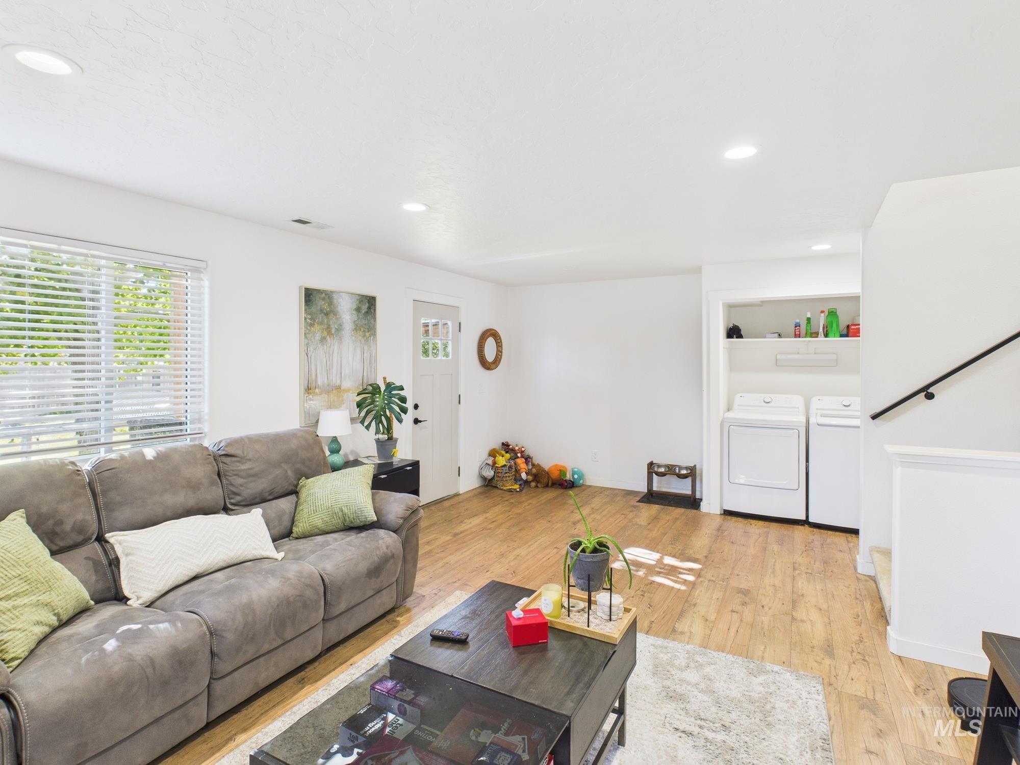 Living area featuring recessed lighting, washing machine and clothes dryer, and light wood-style floors