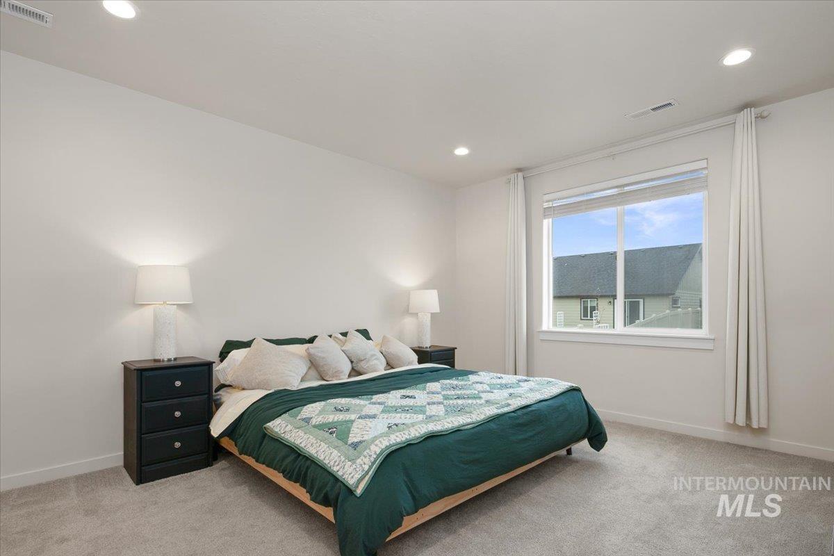 Bedroom with light carpet and recessed lighting