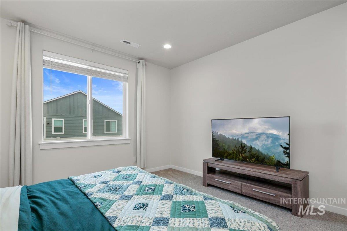 Bedroom with light colored carpet and recessed lighting