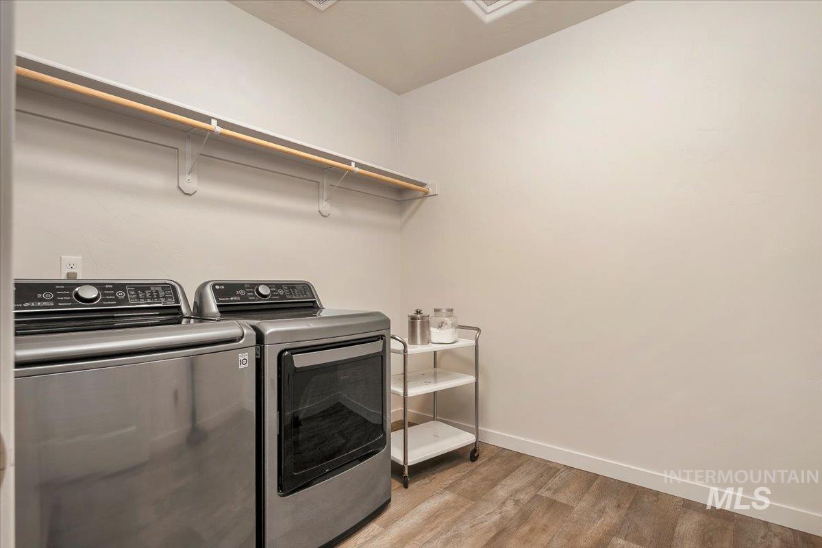 Washroom with light wood finished floors and washer and clothes dryer
