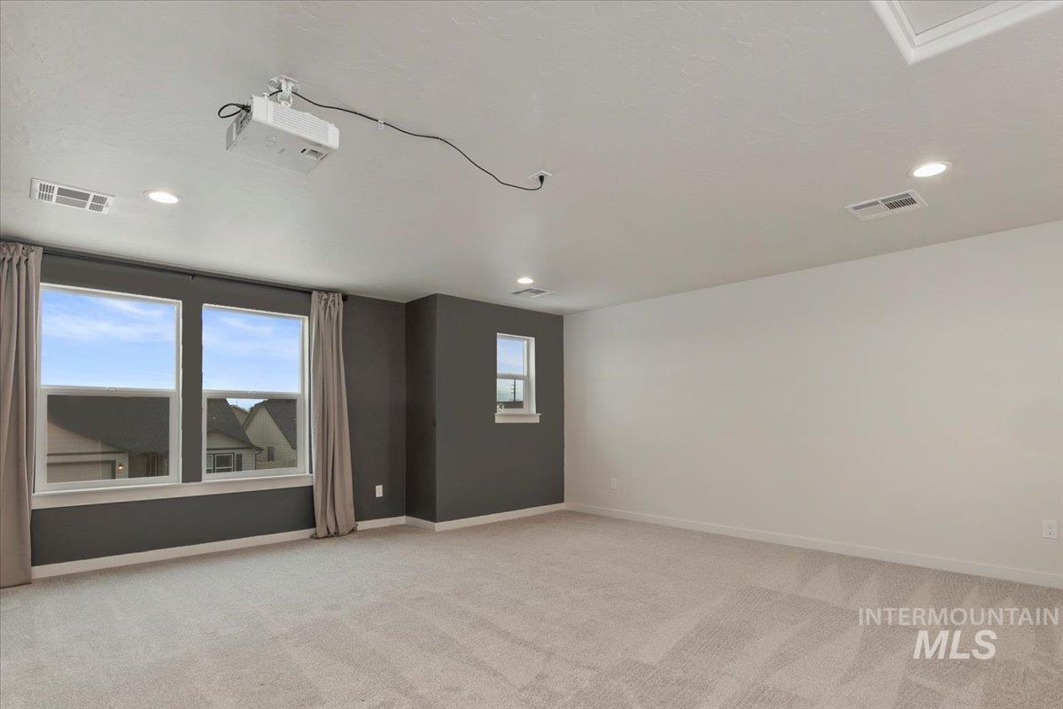 Spare room featuring light colored carpet and recessed lighting