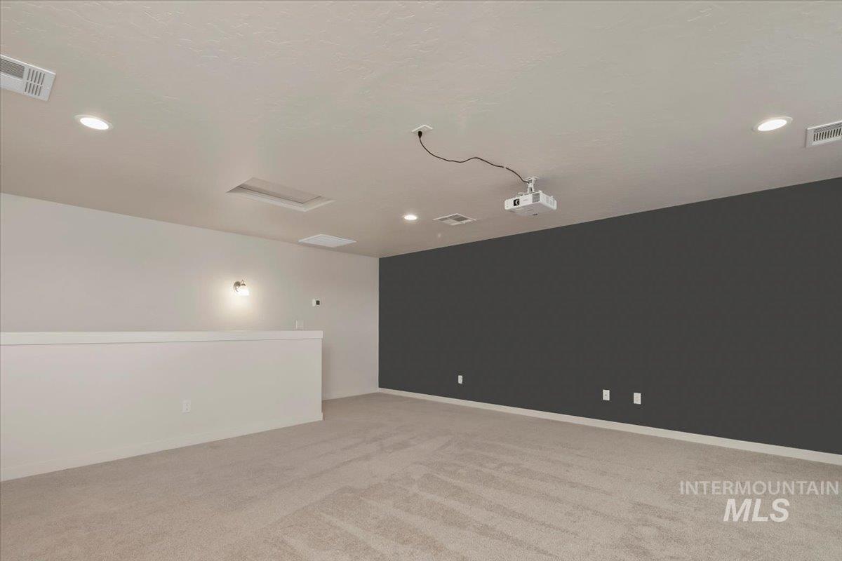 Spare room featuring light carpet, recessed lighting, and attic access