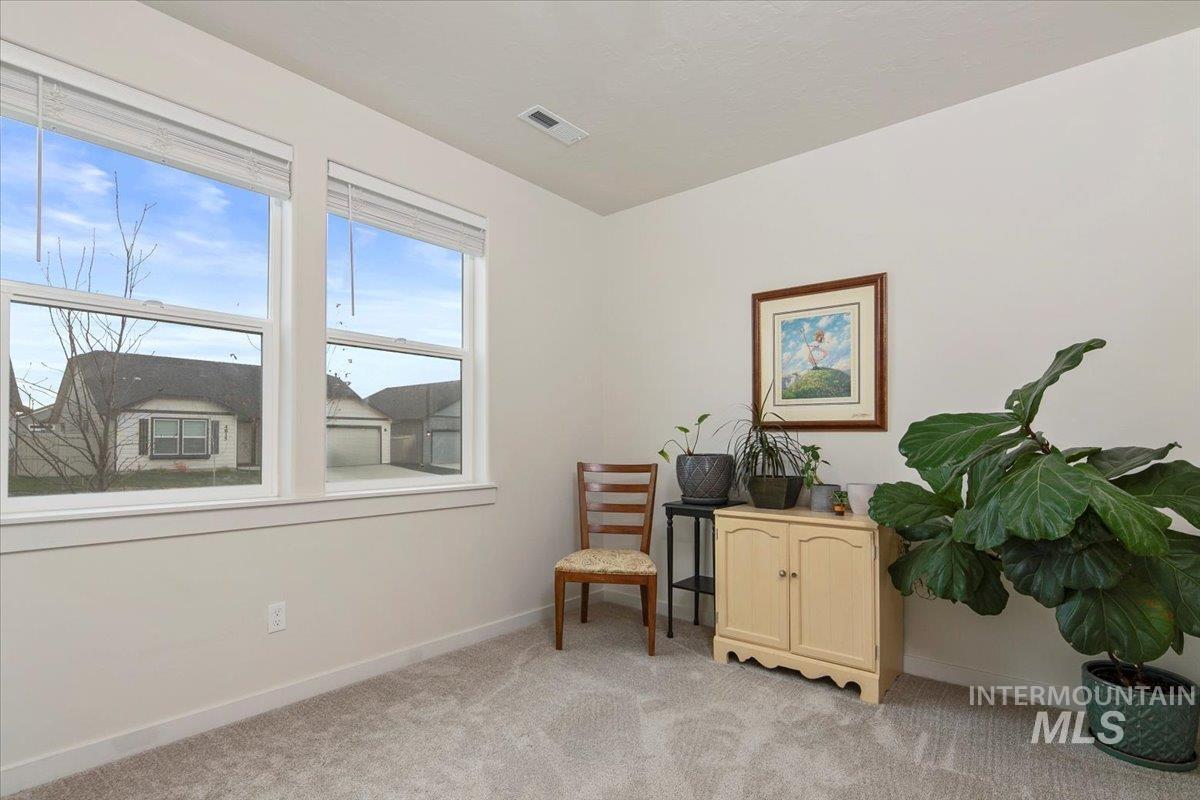 Living area featuring light colored carpet and baseboards