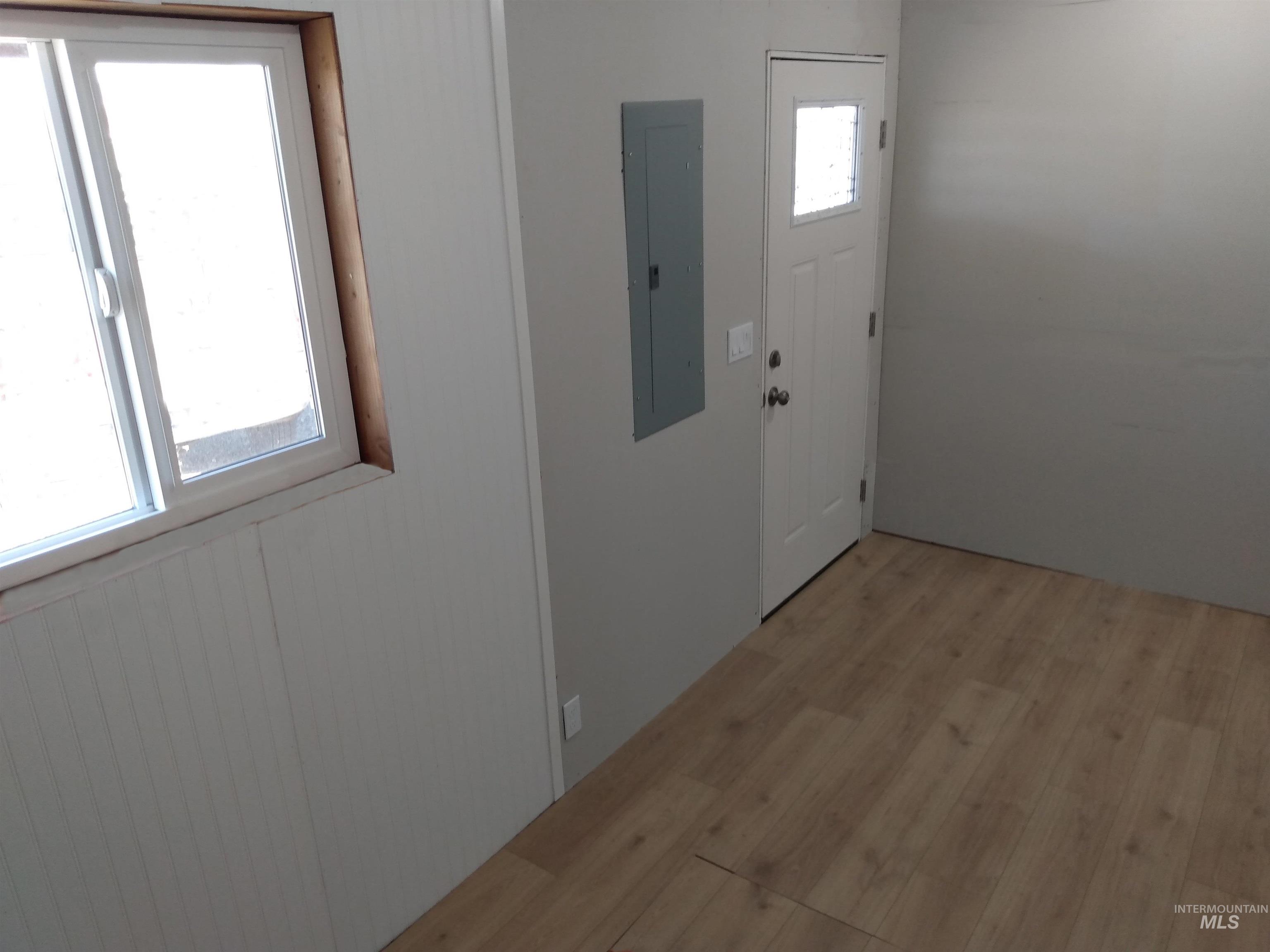 Foyer entrance with light wood finished floors and electric panel