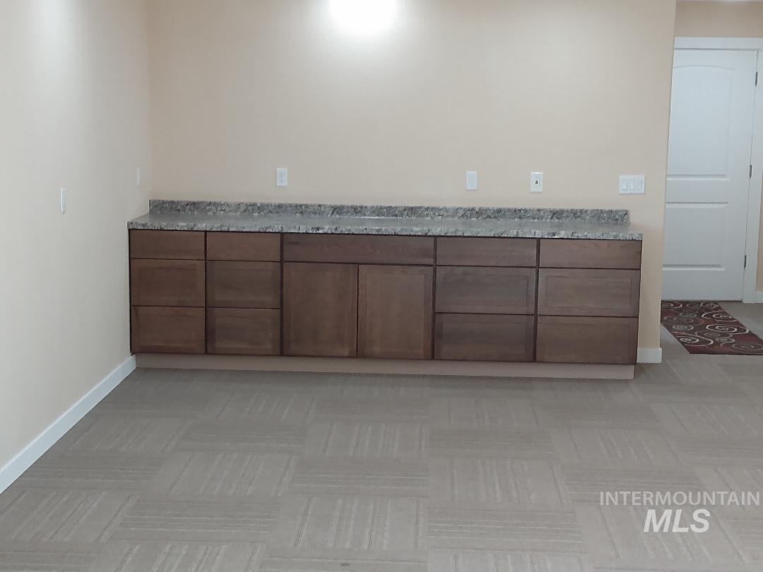 Bar featuring brown cabinetry and baseboards