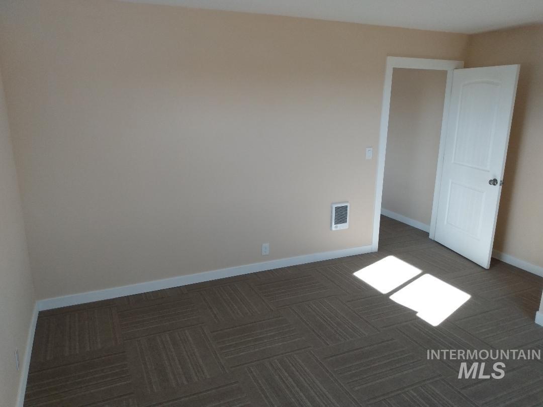 Carpeted empty room with baseboards