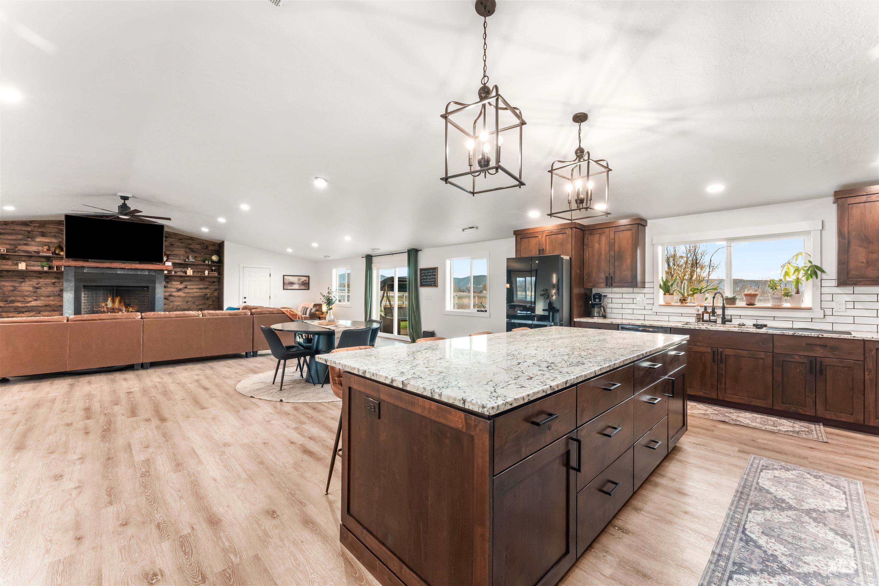 Kitchen featuring a kitchen bar, a center island, plenty of natural light, light stone counters, and lofted ceiling
