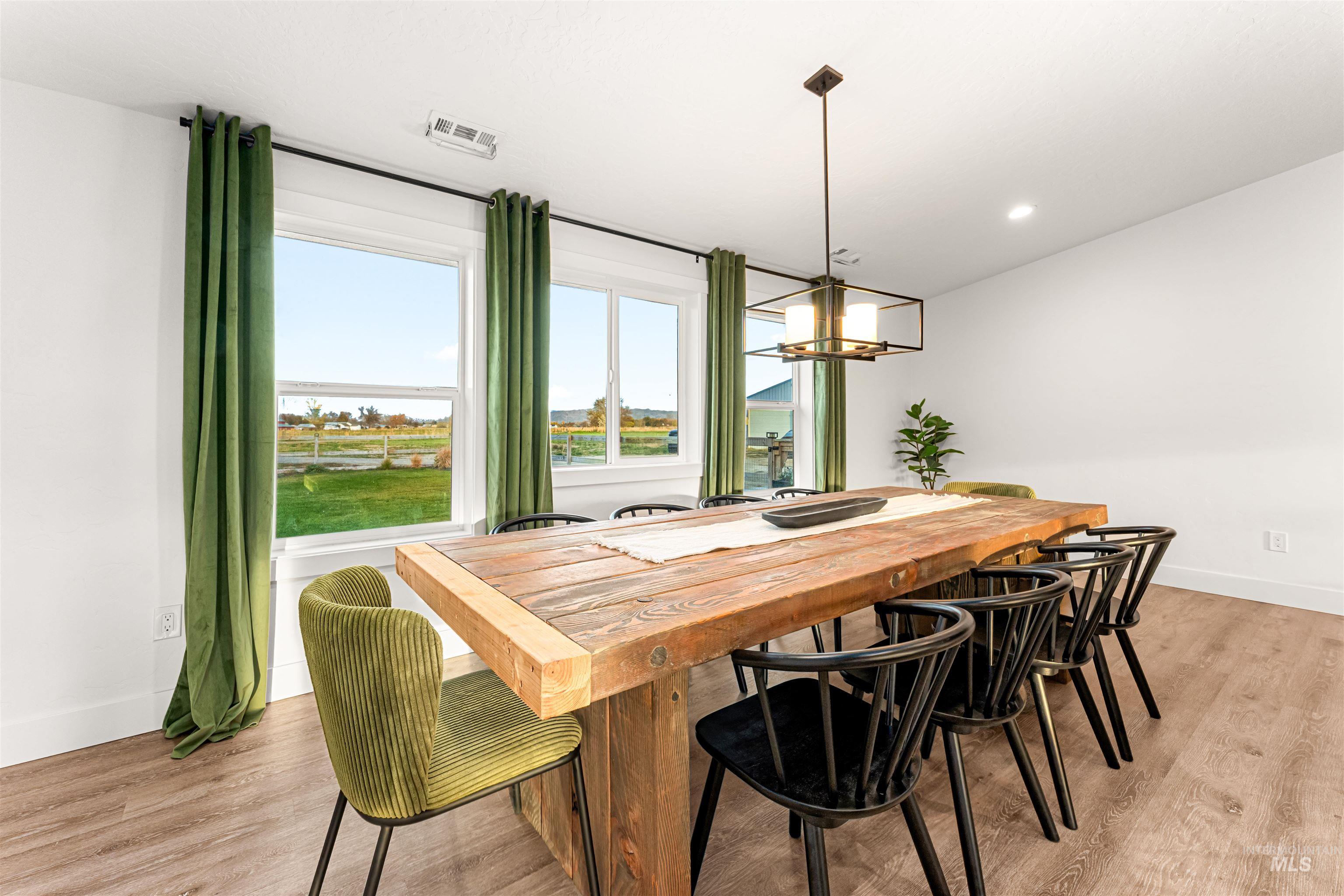 Dining room with light wood-type flooring, a chandelier, and recessed lighting