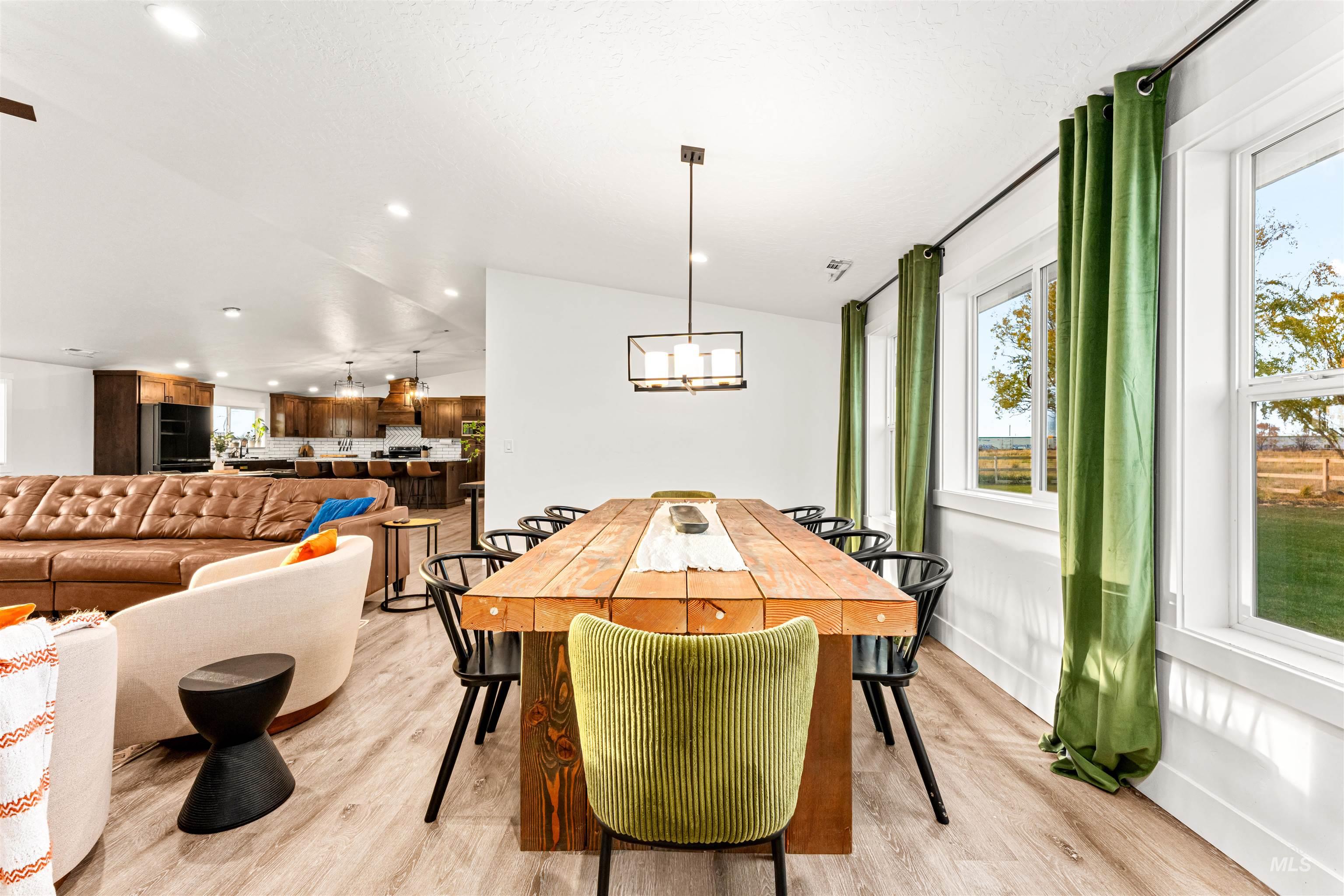 Dining area featuring light wood finished floors, vaulted ceiling, recessed lighting, and a chandelier