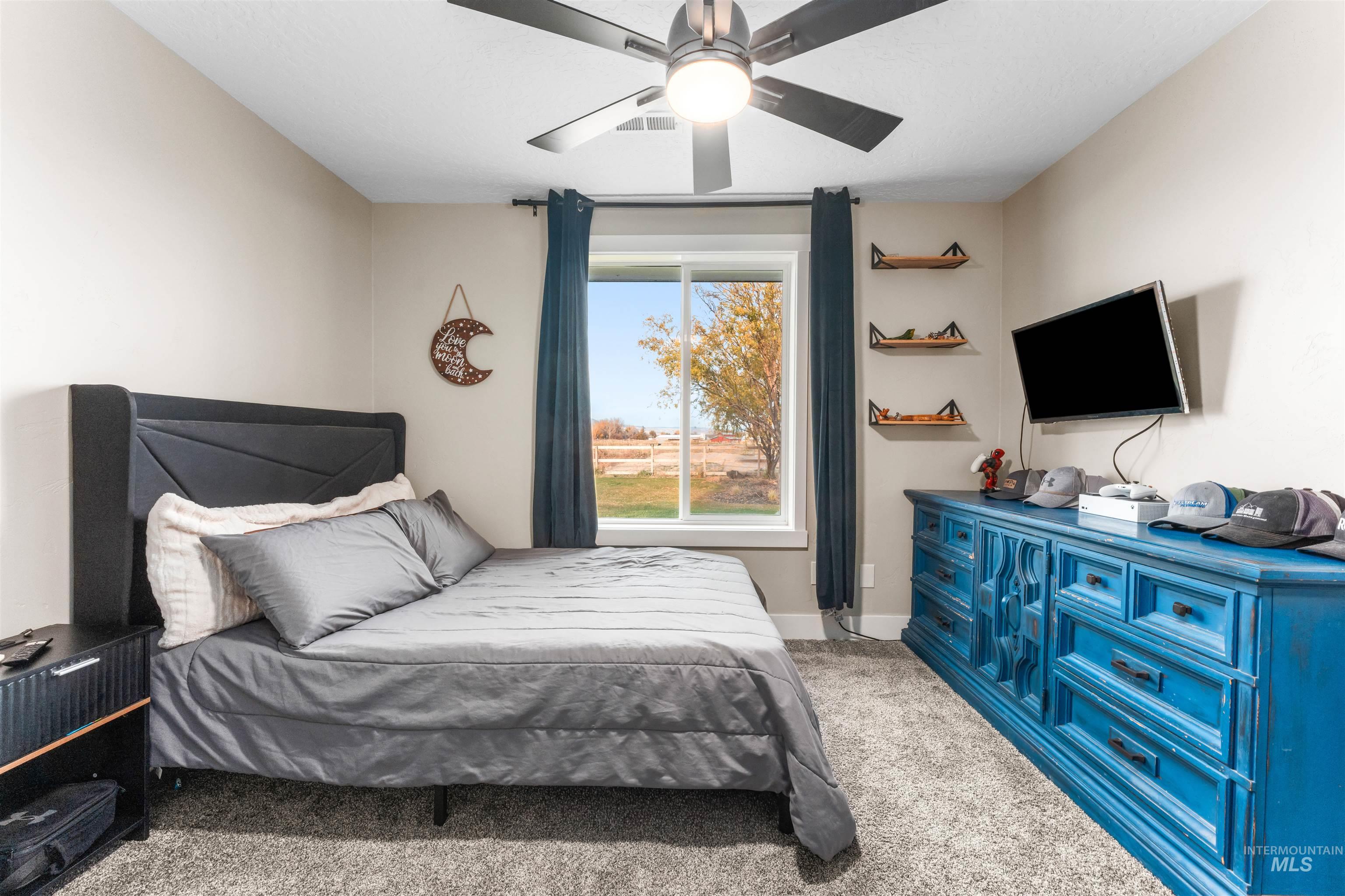 Bedroom with light carpet and a ceiling fan