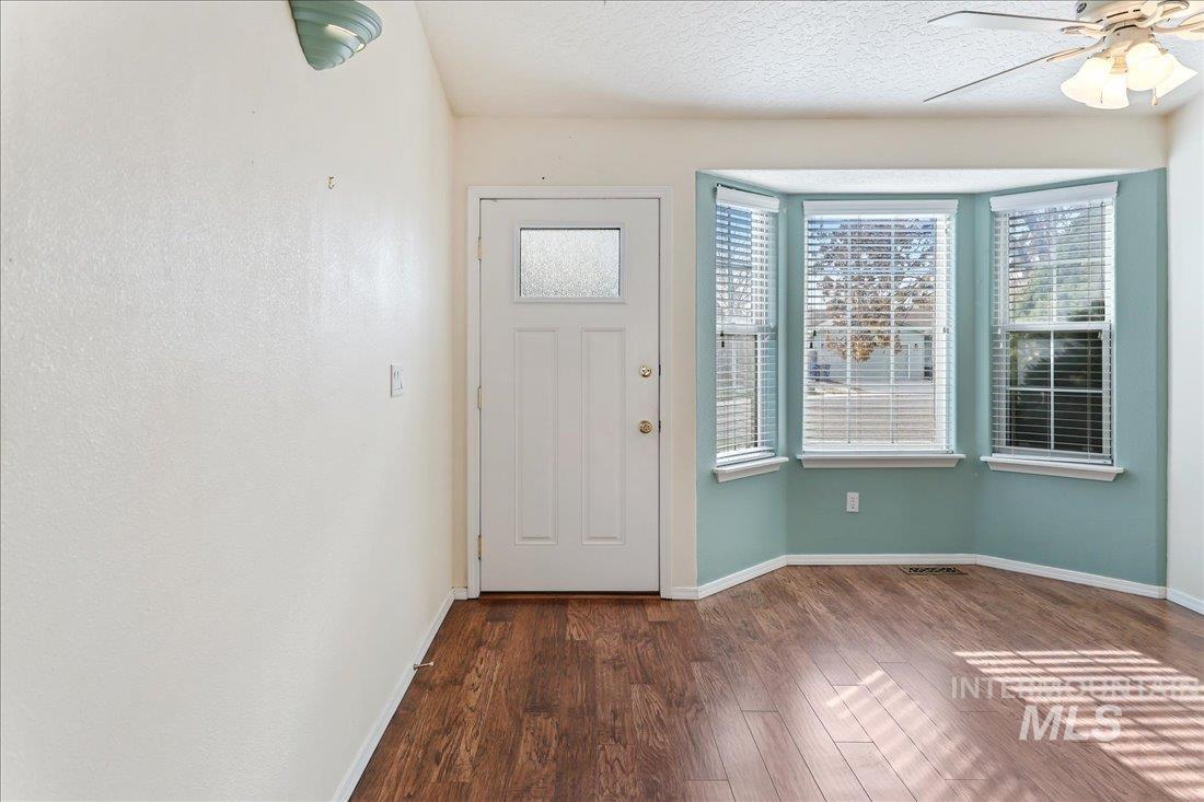 Foyer with dark wood-style flooring, a ceiling fan, and a textured ceiling
