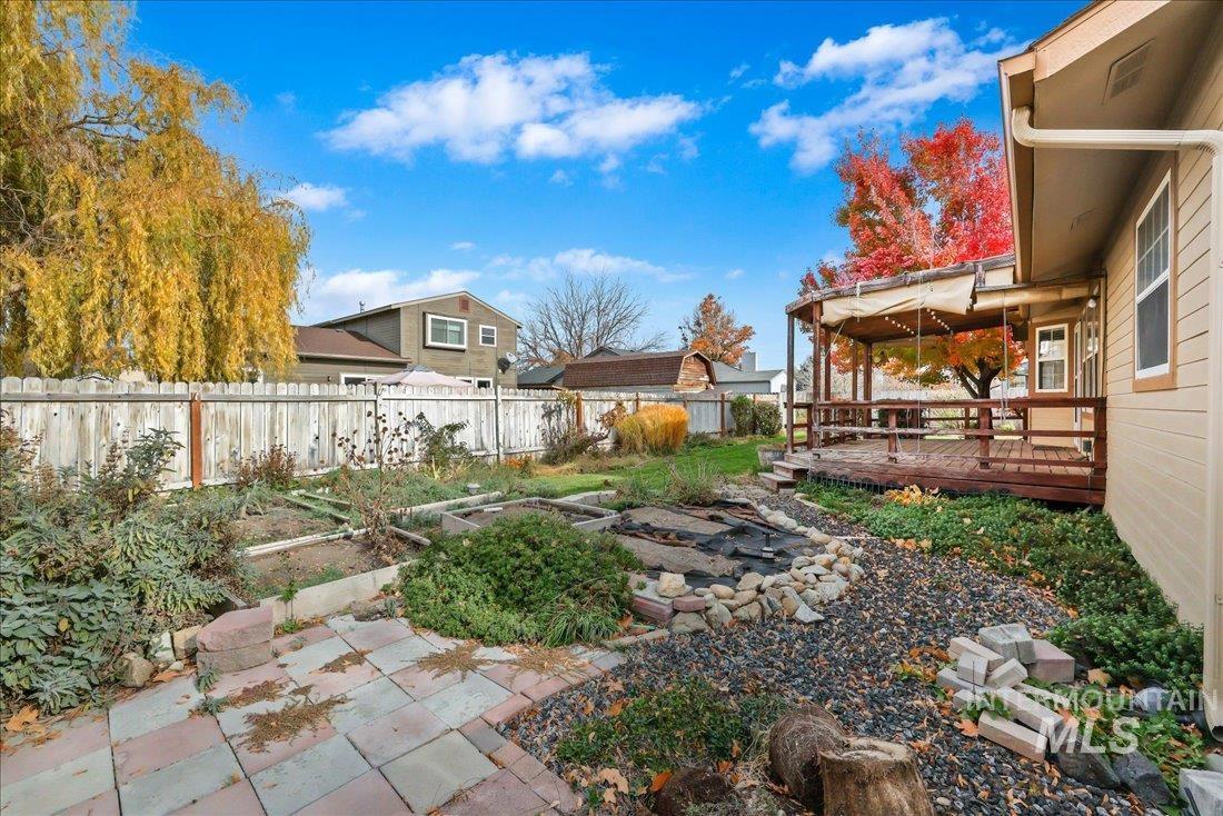 Fenced backyard with a vegetable garden and a deck
