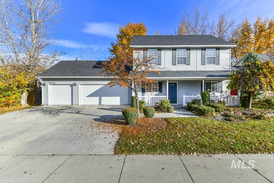 Traditional home with covered porch, an attached garage, and driveway