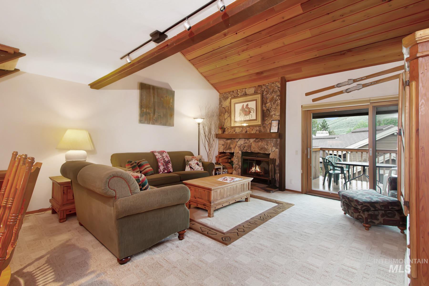 Living area with light colored carpet and a stone fireplace
