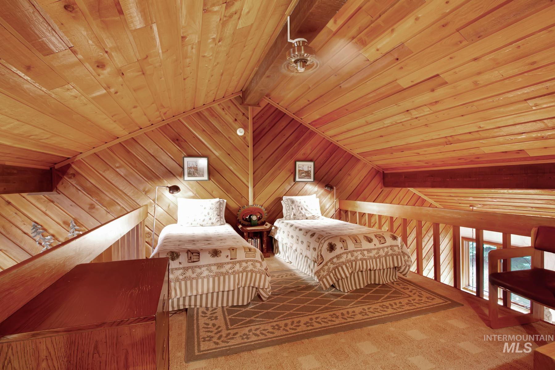 Living area featuring wood ceiling, wood walls, and carpet floors