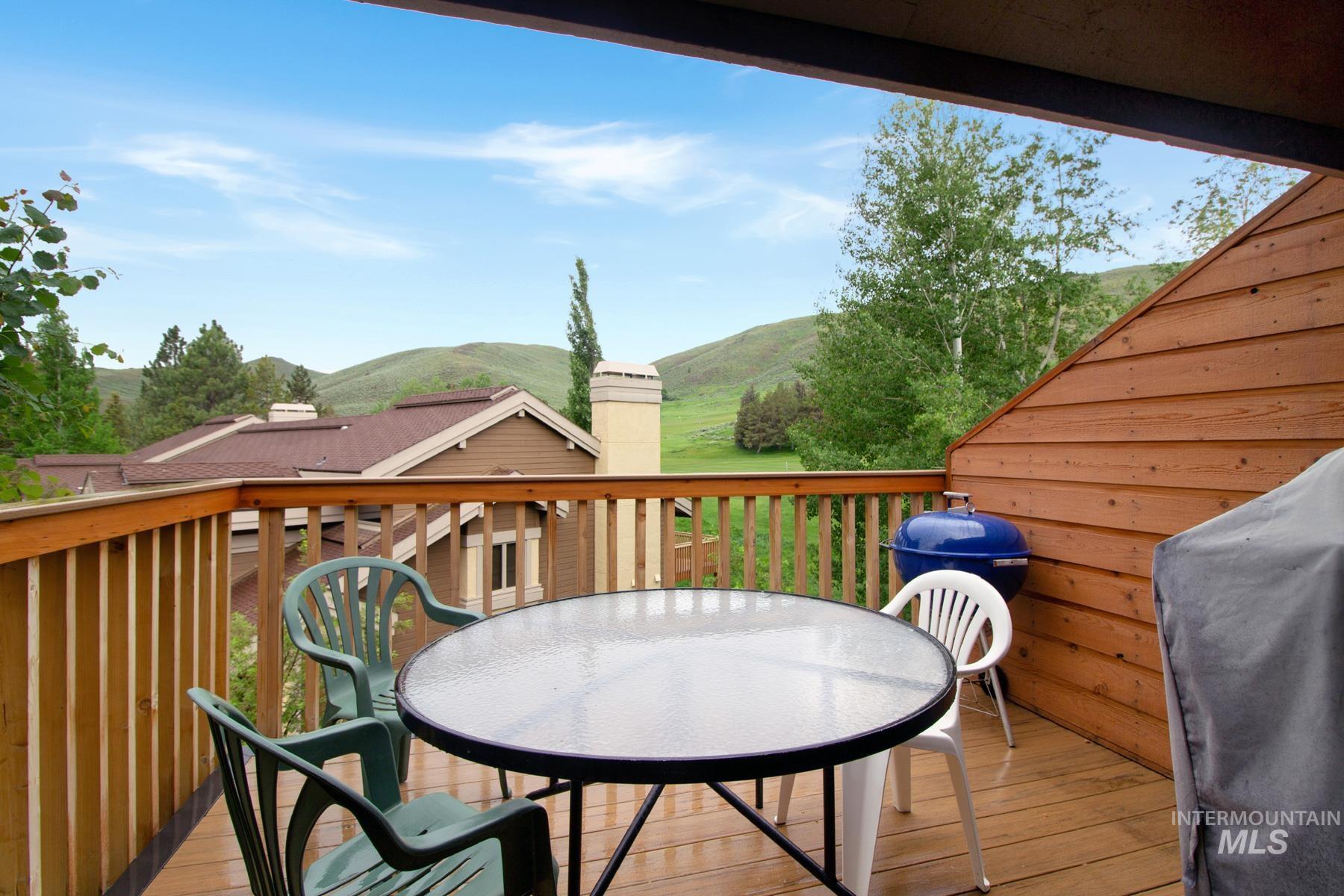 Deck featuring outdoor dining area, a mountain view, and a grill