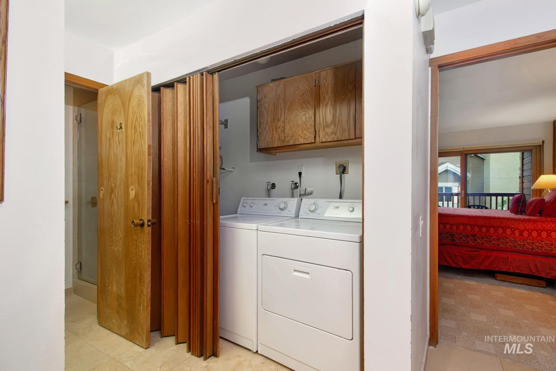Laundry area featuring washer and clothes dryer and cabinet space