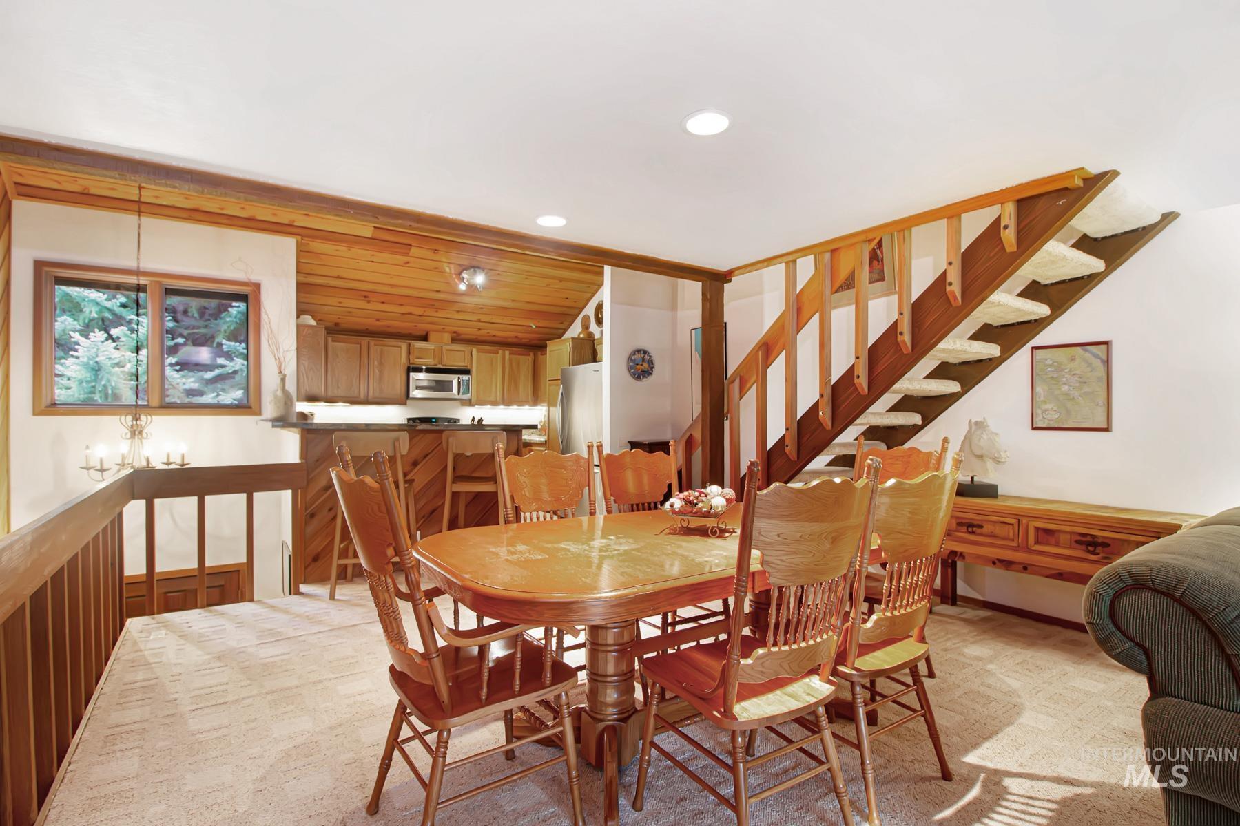 Dining area with recessed lighting, stairs, and light carpet