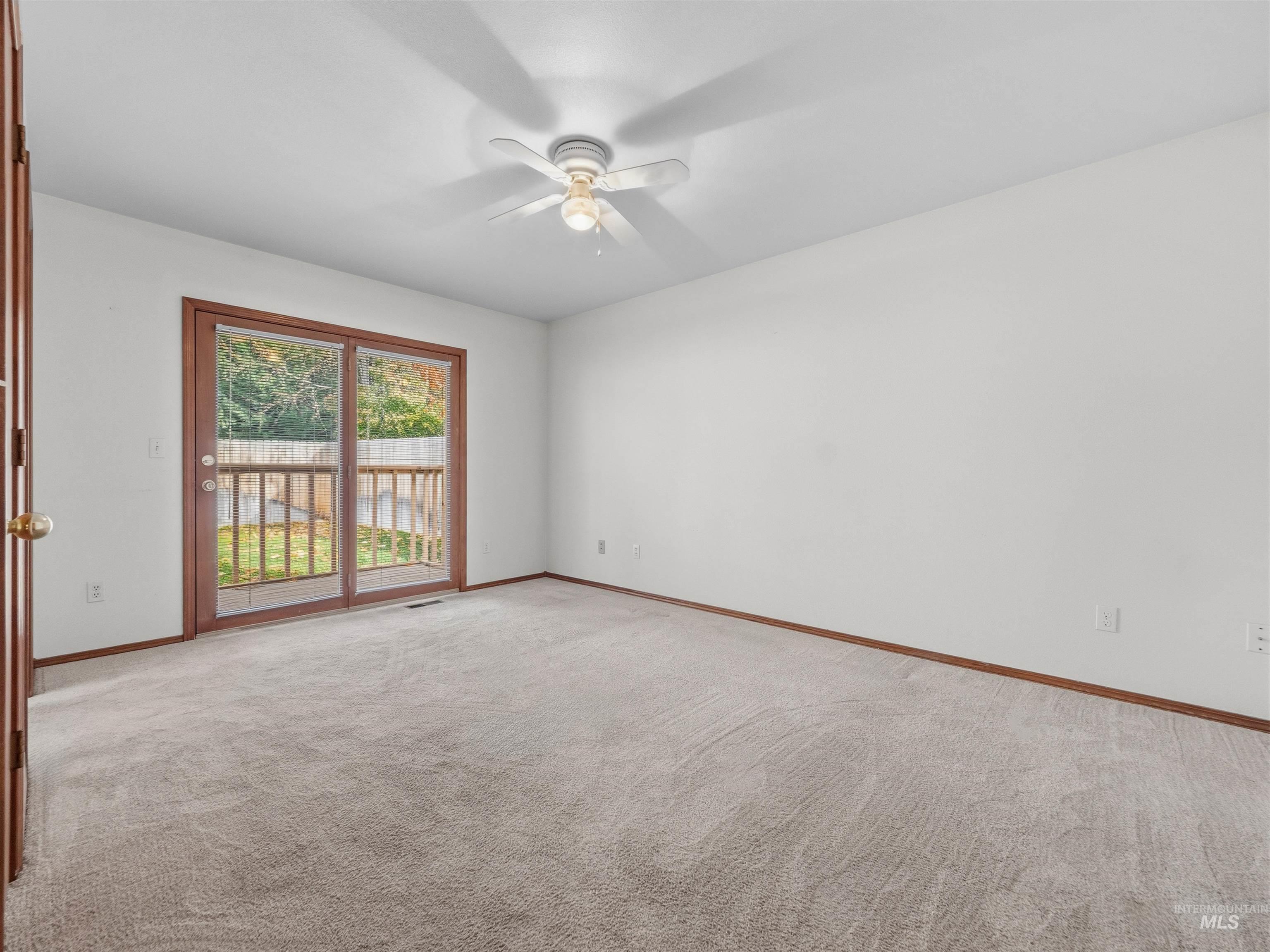 Spare room featuring light carpet and a ceiling fan