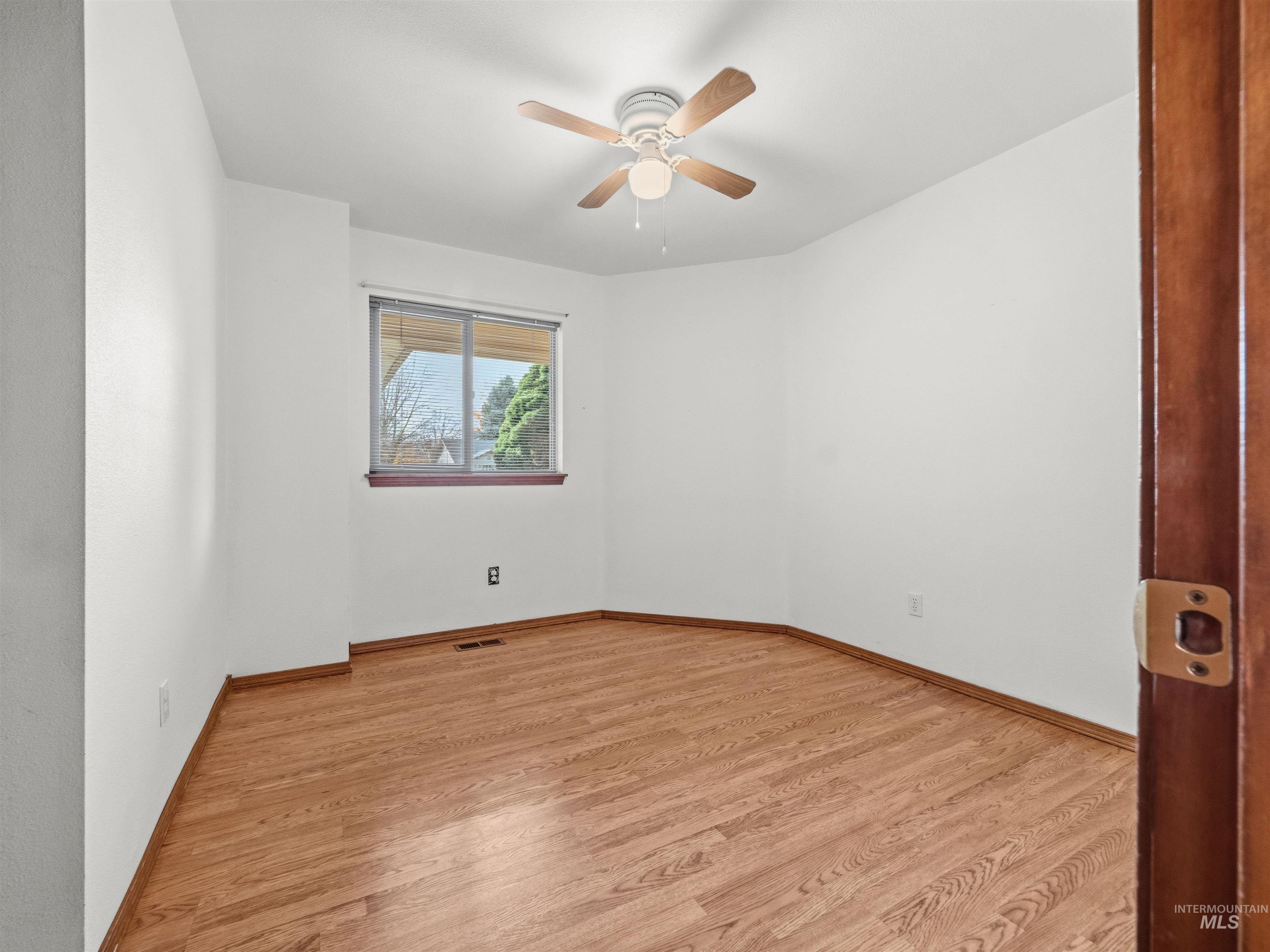 Unfurnished room with light wood finished floors and a ceiling fan