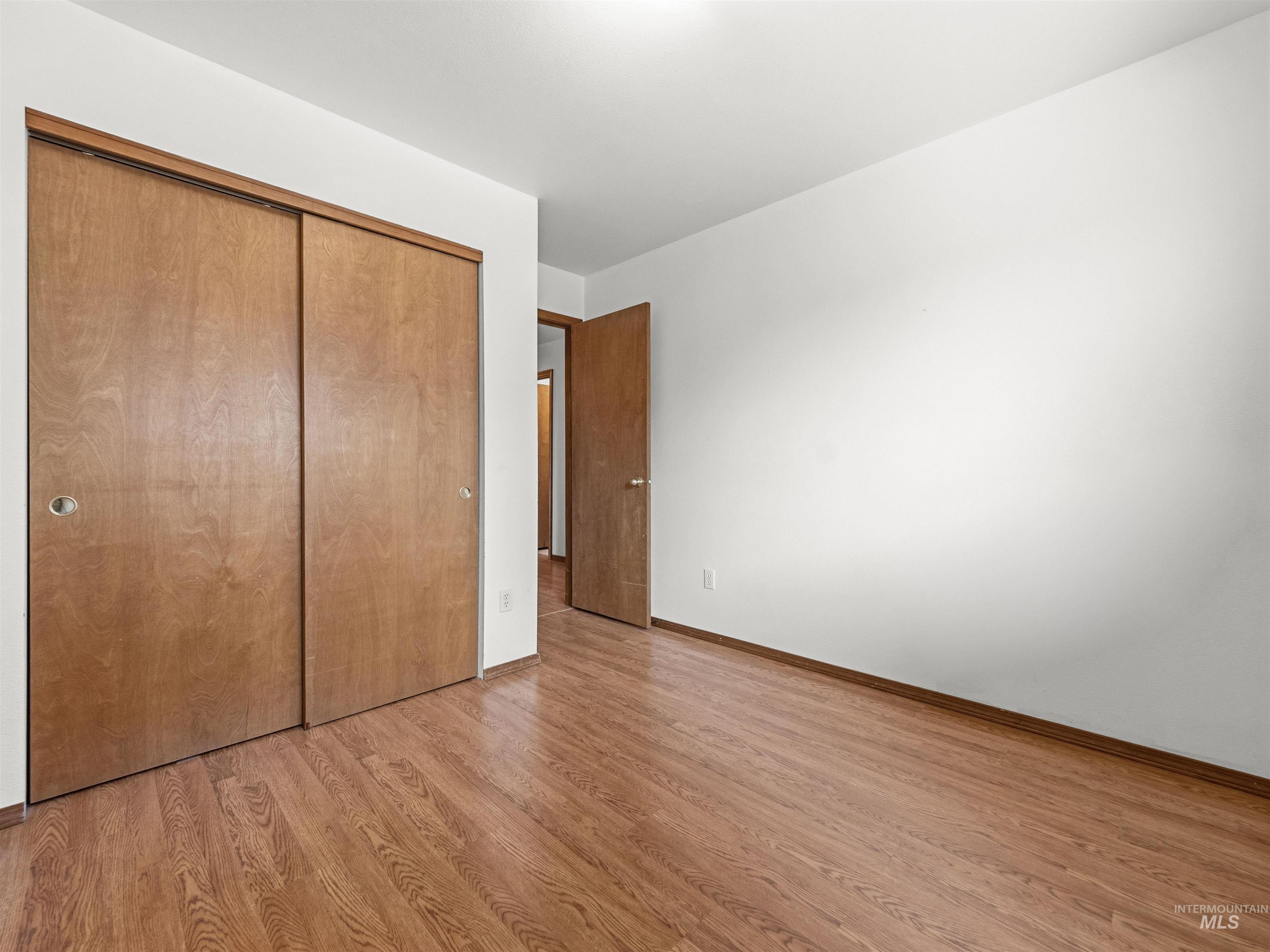 Unfurnished bedroom featuring light wood-style flooring and a closet