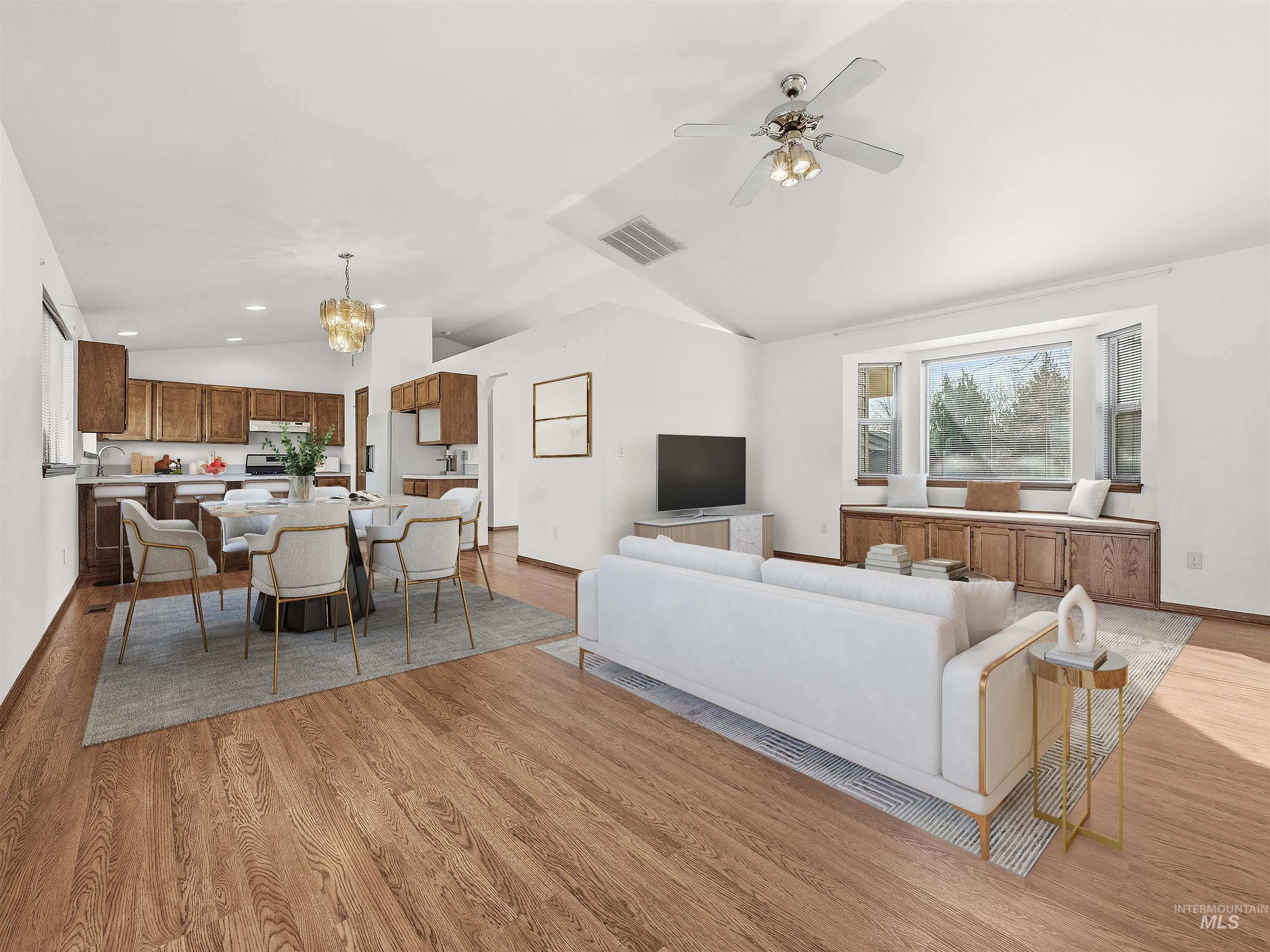 Living room with vaulted ceiling, a chandelier, light wood-style flooring, a ceiling fan, and recessed lighting