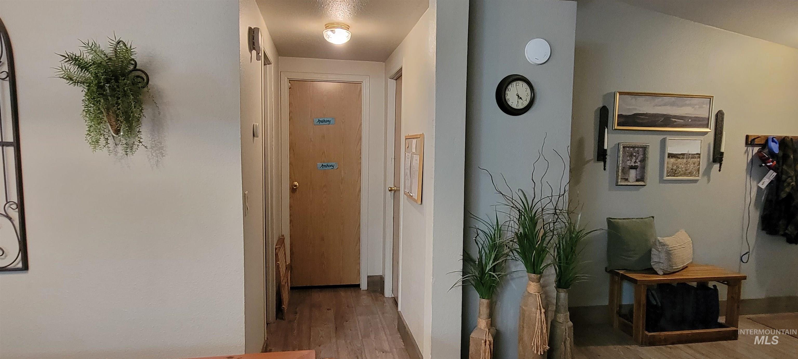 Corridor with light wood-style floors and baseboards