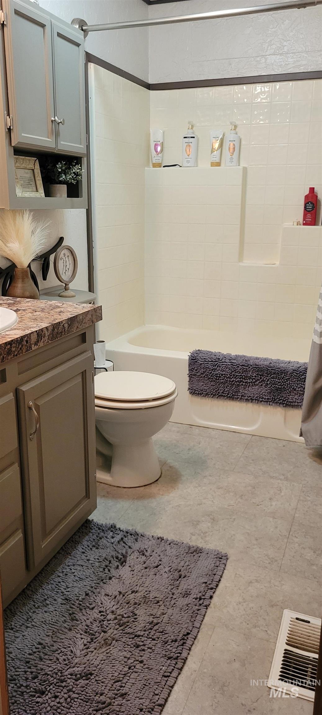 Full bath featuring shower / tub combo, vanity, and light tile patterned floors