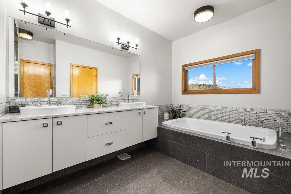 Full bathroom featuring double vanity and a bath