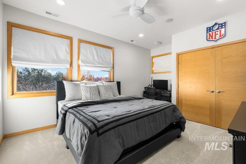 Bedroom with light colored carpet, a ceiling fan, and recessed lighting