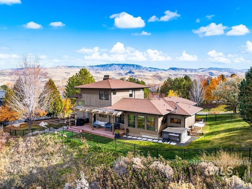 Back of property featuring a fenced backyard, a mountain view, and a patio