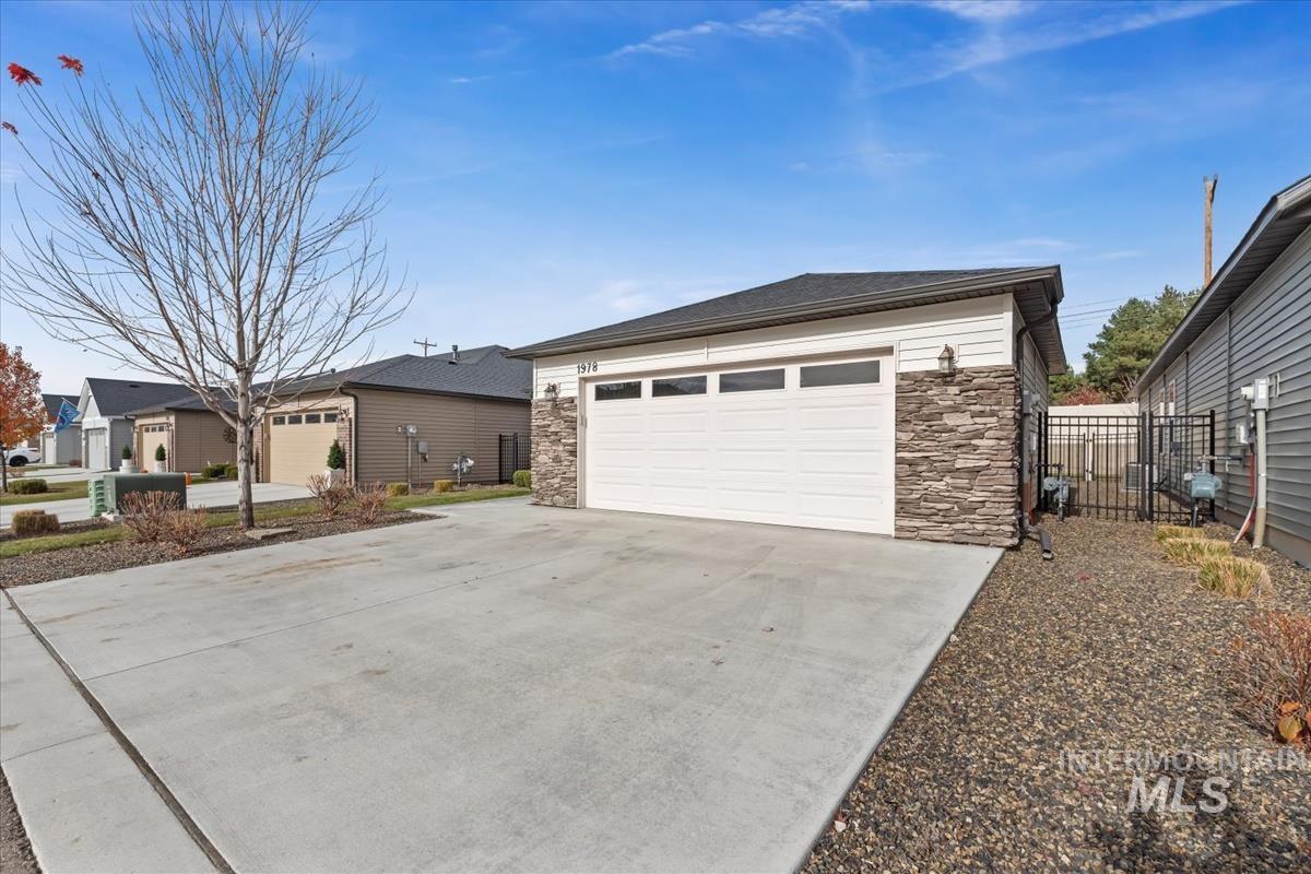 View of front of home with stone siding and concrete driveway