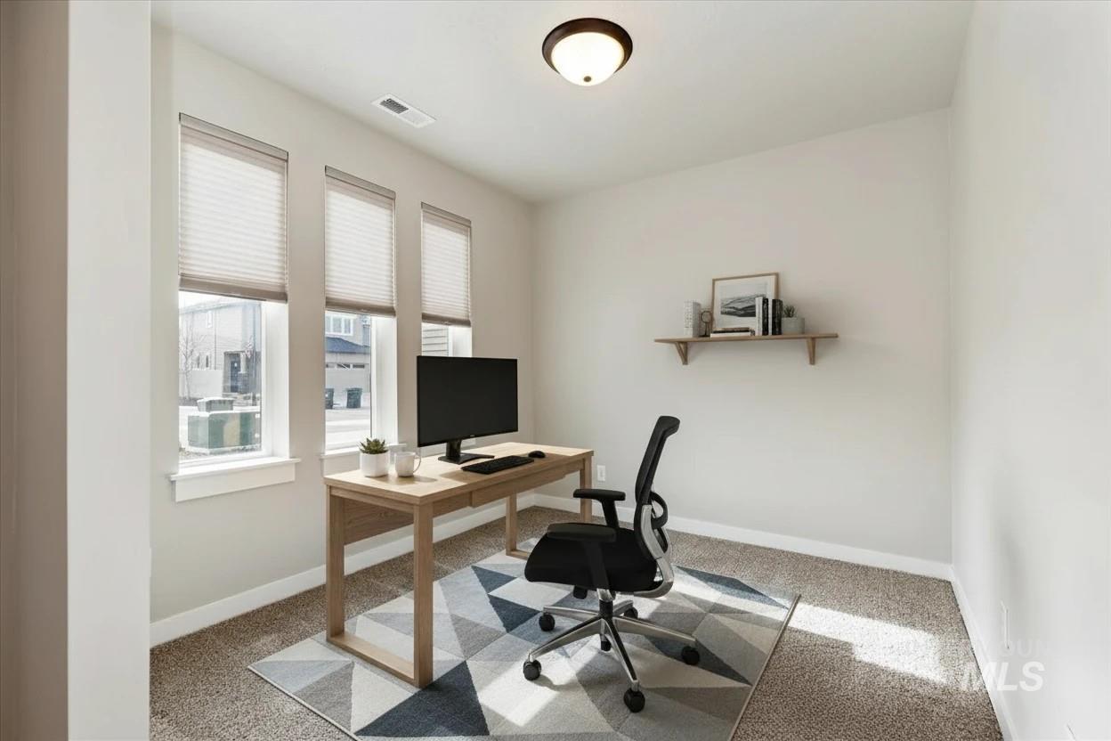 Home office with light colored carpet and baseboards