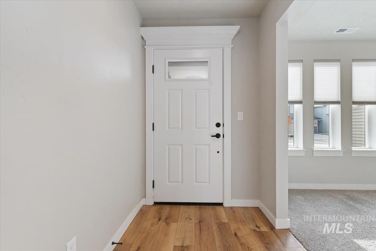 Entryway with baseboards and light wood-style flooring