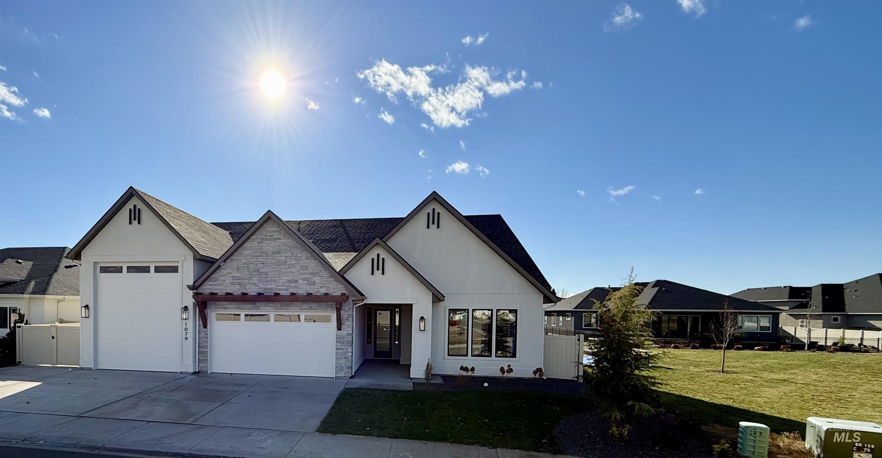 View of front facade featuring an attached garage, concrete driveway, stucco siding, a front yard, and stone siding