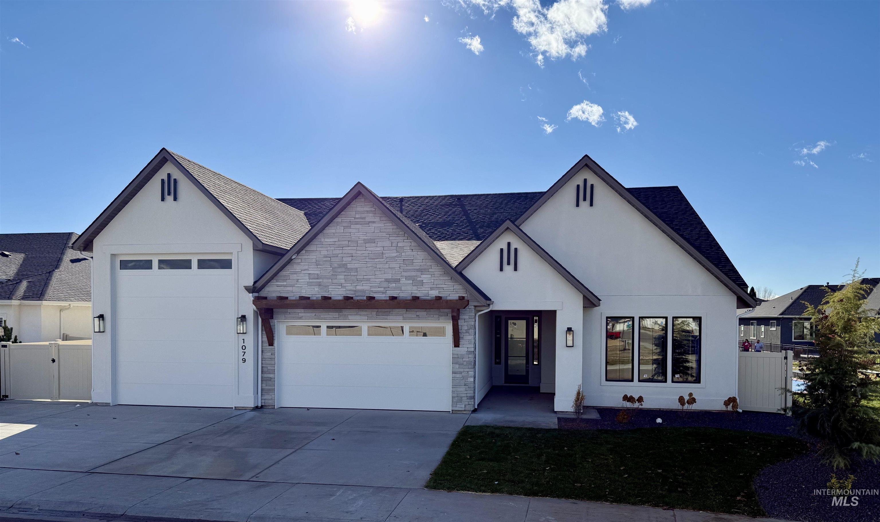 View of front of property with an attached garage, driveway, roof with shingles, and stone siding