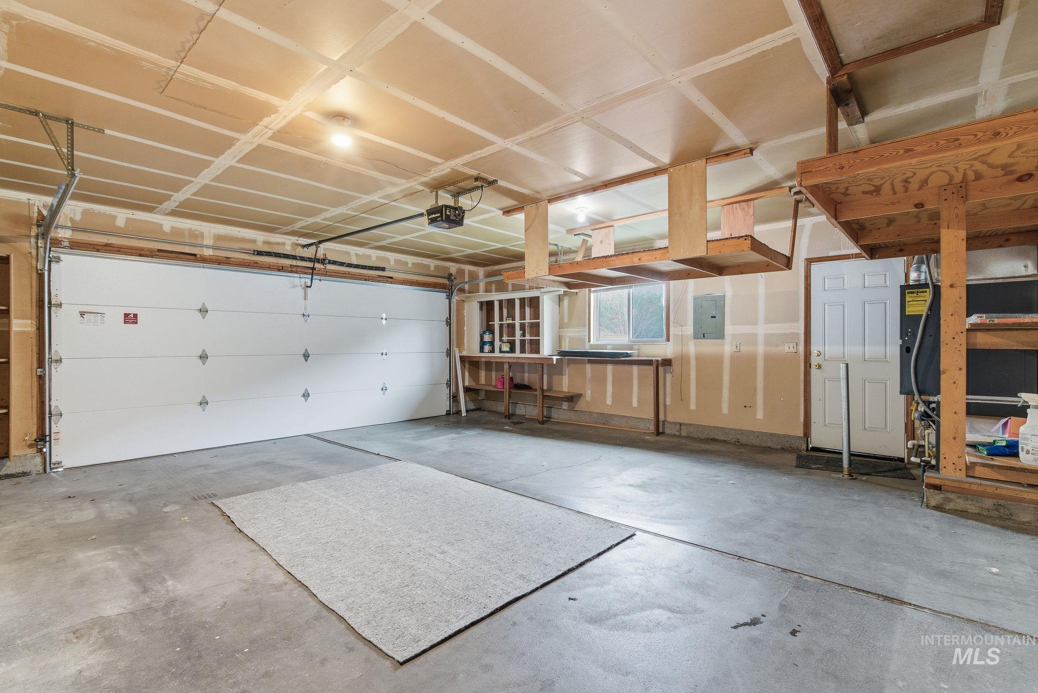 Garage featuring electric panel and a garage door opener