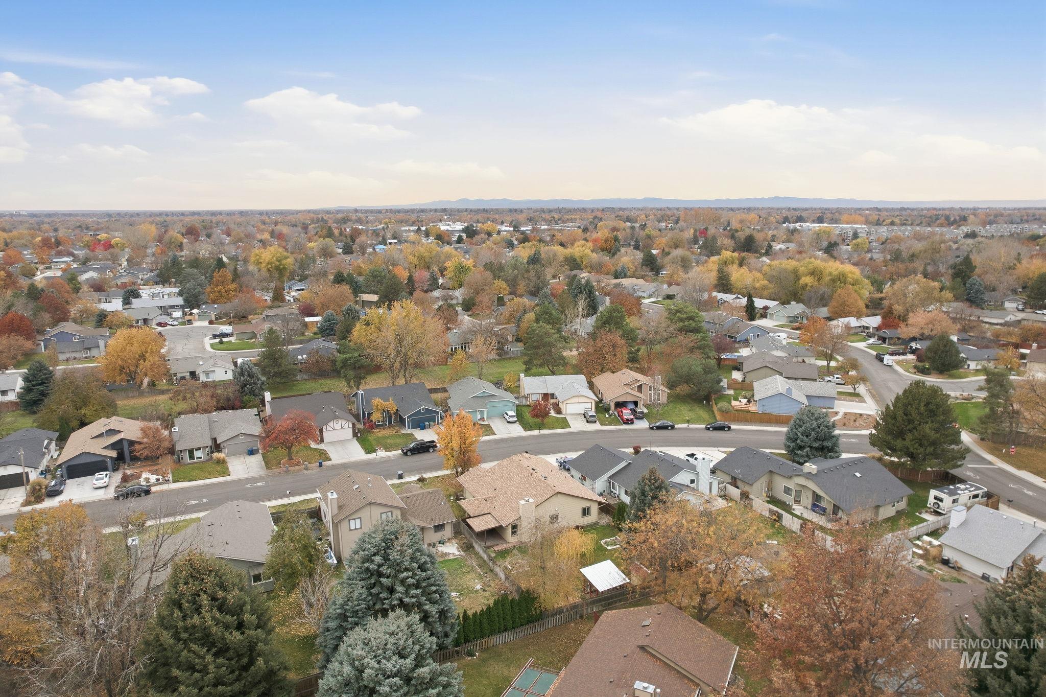 Aerial view of property and surrounding area with nearby suburban area